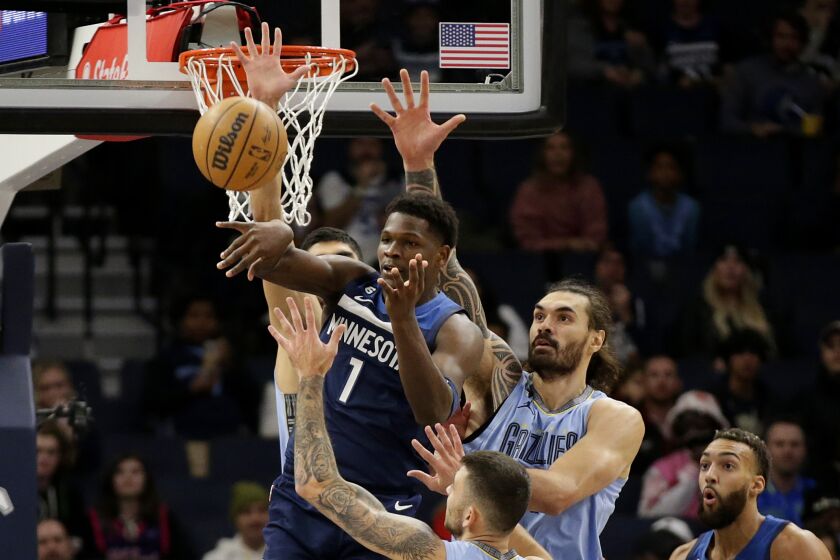 Minnesota Timberwolves guard Anthony Edwards (1) passes under pressure from Memphis Grizzlies center Anthony Edwards (4) in the first quarter of an NBA basketball game Wednesday, Nov. 30, 2022, in Minneapolis. (AP Photo/Andy Clayton-King)