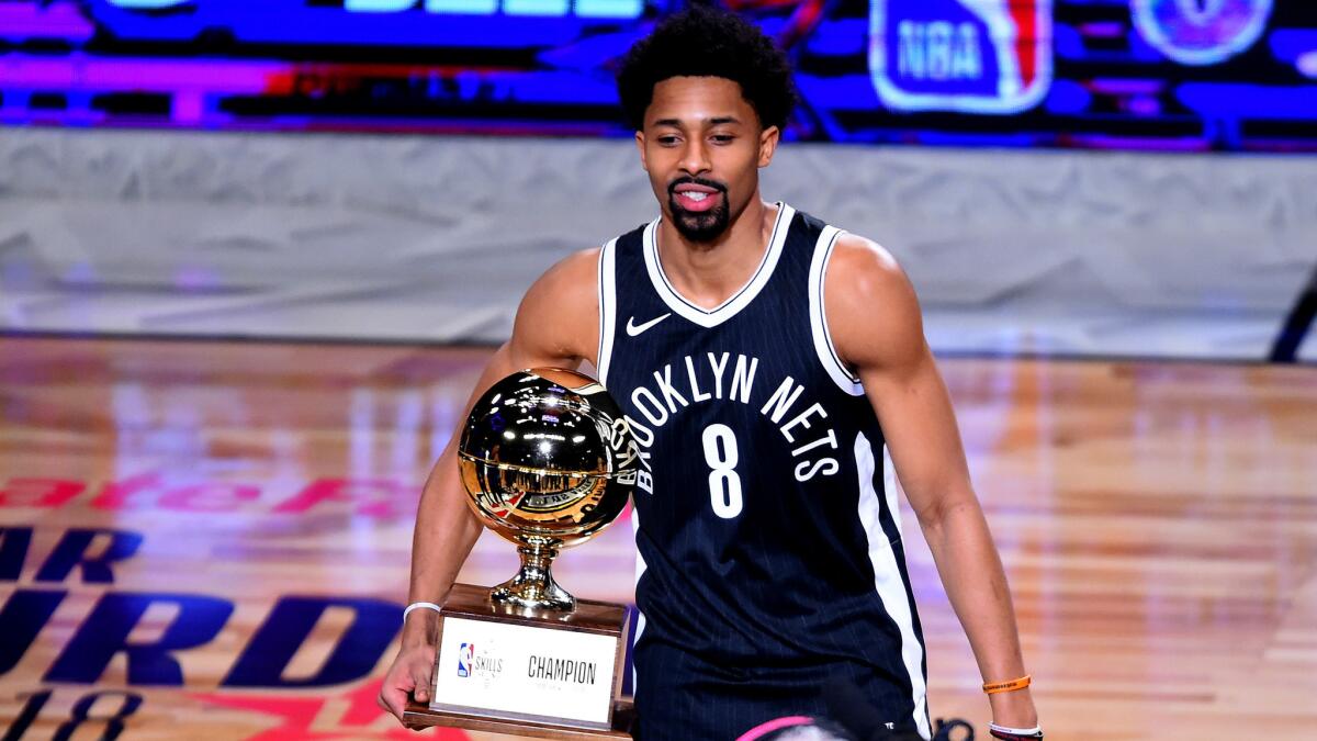 Spencer Dinwiddie of the Brooklyn Nets shows off the Skills Challenge winner's trophy at Staples Center.
