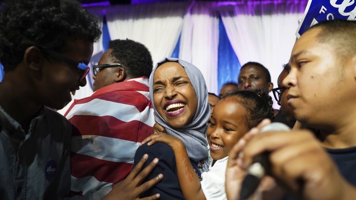 Minnesota state Rep. Ilhan Omar celebrates with her children after her primary victory in August. She'll become one of the first Muslim women in Congress if she wins in Tuesday's election.