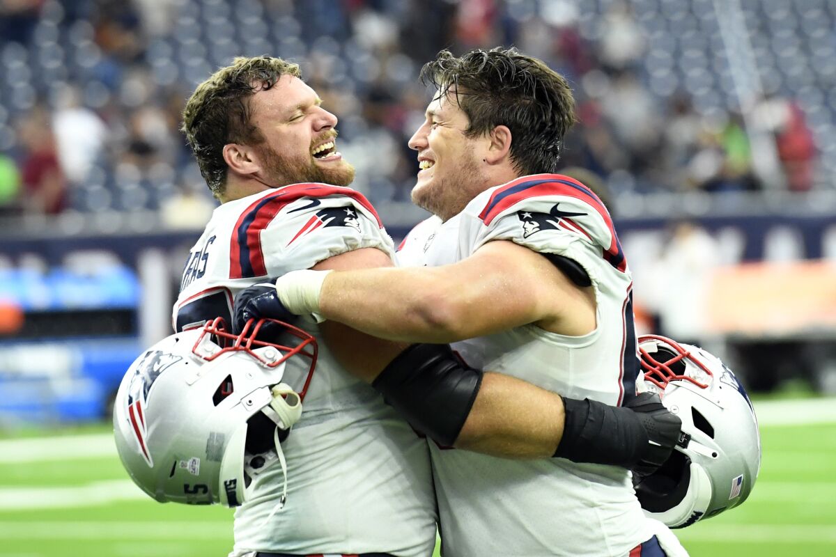 New England Patriots' Ted Karras, left, and James Ferentz celebrate after an NFL football game against the Houston Texans Sunday, Oct. 10, 2021, in Houston. (AP Photo/Justin Rex)