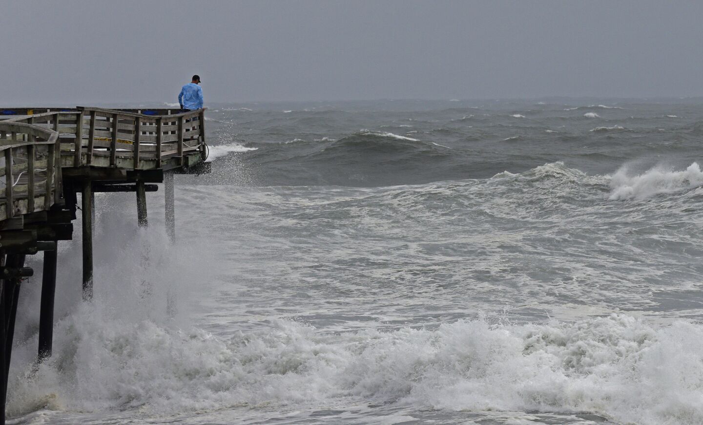 An onlooker checks out the heavy surf at the Avalon Fishing Pier in Kill Devil Hills, N.C., Thursday, Sept. 13, 2018 as Hurricane Florence approaches the east coast.