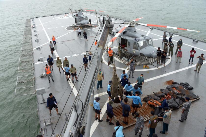 Bodies recovered from AirAsia Flight 8501 are prepared for transport ashore from an Indonesian navy vessel off the coast of Pangkalan Bun, Indonesia on Jan. 3.