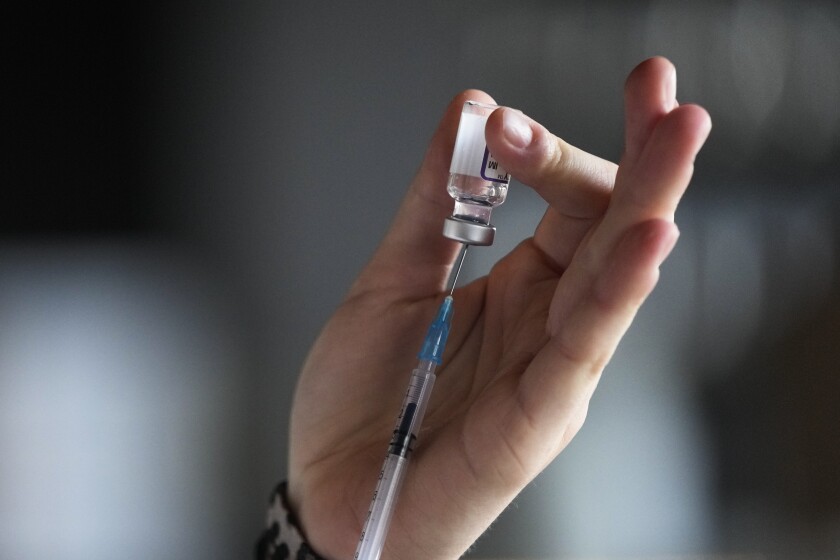 A medical student prepares a syringe with vaccination against the coronavirus and the COVID-19 disease inside Klunkerkranich Restaurant and night club during an ongoing vaccination campaign of the Clubkommission in Berlin, Germany, Wednesday, Jan. 5, 2022. German Health Minister Karl Lauterbach renewed an appeal for vaccine holdouts to reconsider. He said people who remain unvaccinated in Germany can't expect contact restrictions for them to be lifted "in the short- or medium-term." The Clubcommission Berlin, an association that protects and supports the Berlin club culture. (AP Photo/Markus Schreiber)
