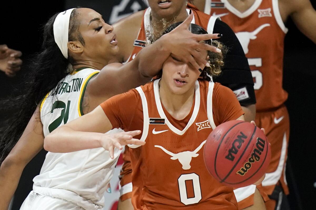 Texas guard Celeste Taylor (0) is fouled by Baylor guard DiJonai Carrington (21) during the second half of an NCAA college basketball game in the semifinal round of the Big 12 Conference tournament in Kansas City, Mo., Saturday, March 13, 2021. (AP Photo/Orlin Wagner)
