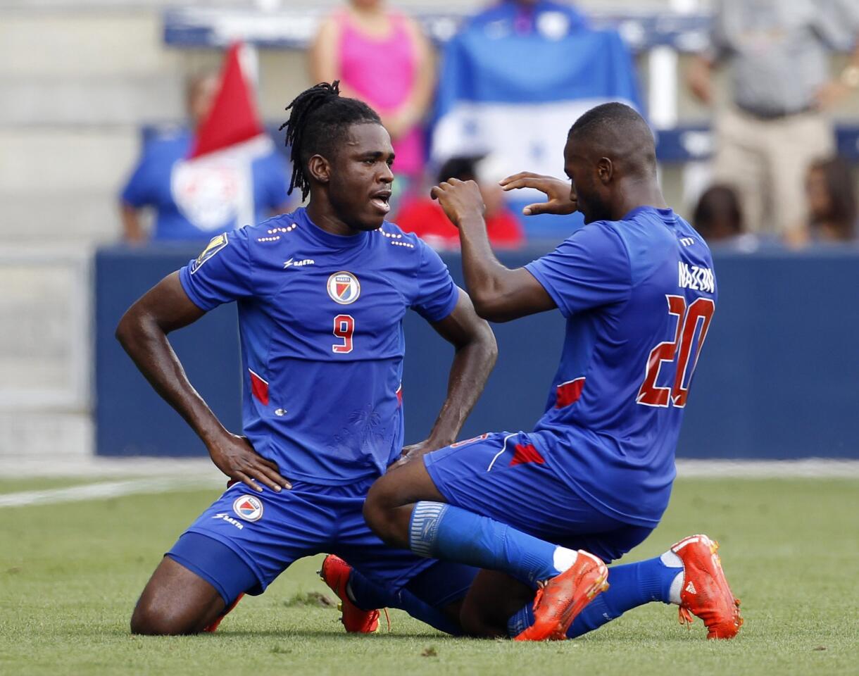 Haiti's Kervens Belfort (9) is congratulated by Duckens Nazon (20) after a goal against Honduras during the first half of a CONCACAF Gold Cup soccer match, Monday, July. 13, 2015, in Kansas City, Kan. Nazon scored off a header from Belfort. (AP Photo/Colin E. Braley)