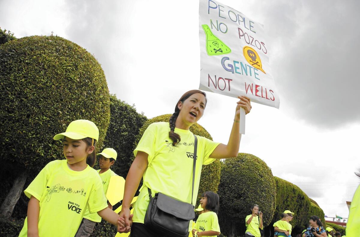 Lisa Placenti, right, and Isabella Placenti, 7, participate in a protest last month against oil drilling in their South Los Angeles neighborhood.