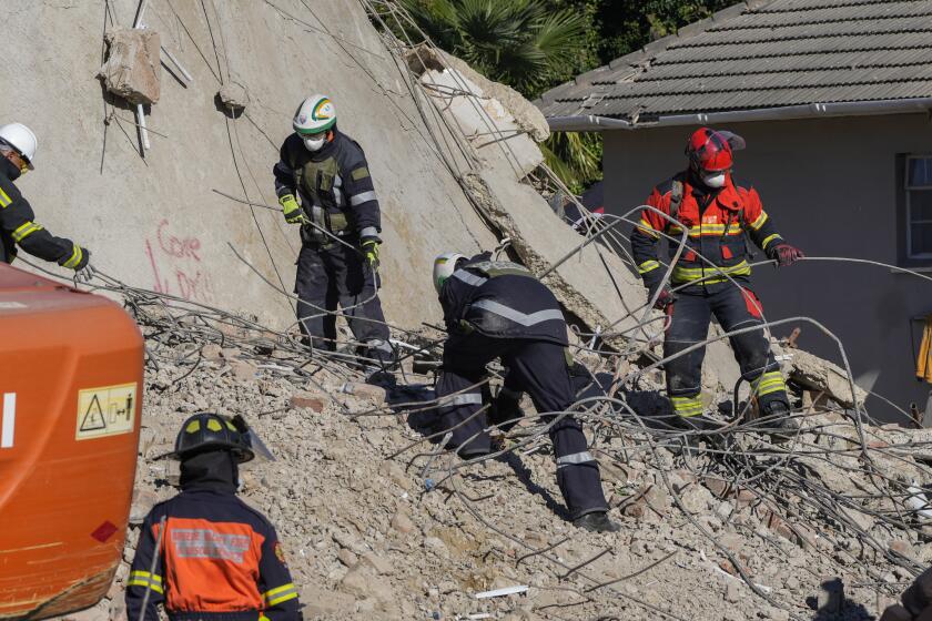 Socorristas buscan entre los escombros de un edificio que se derrumbó en George, Sudáfrica, el jueves 9 de mayo de 2024. (AP Foto/Jerome Delay)