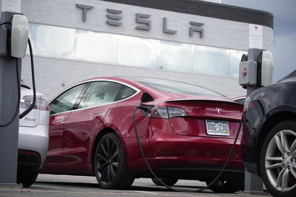 A red 2021 Tesla Model 3 sedan