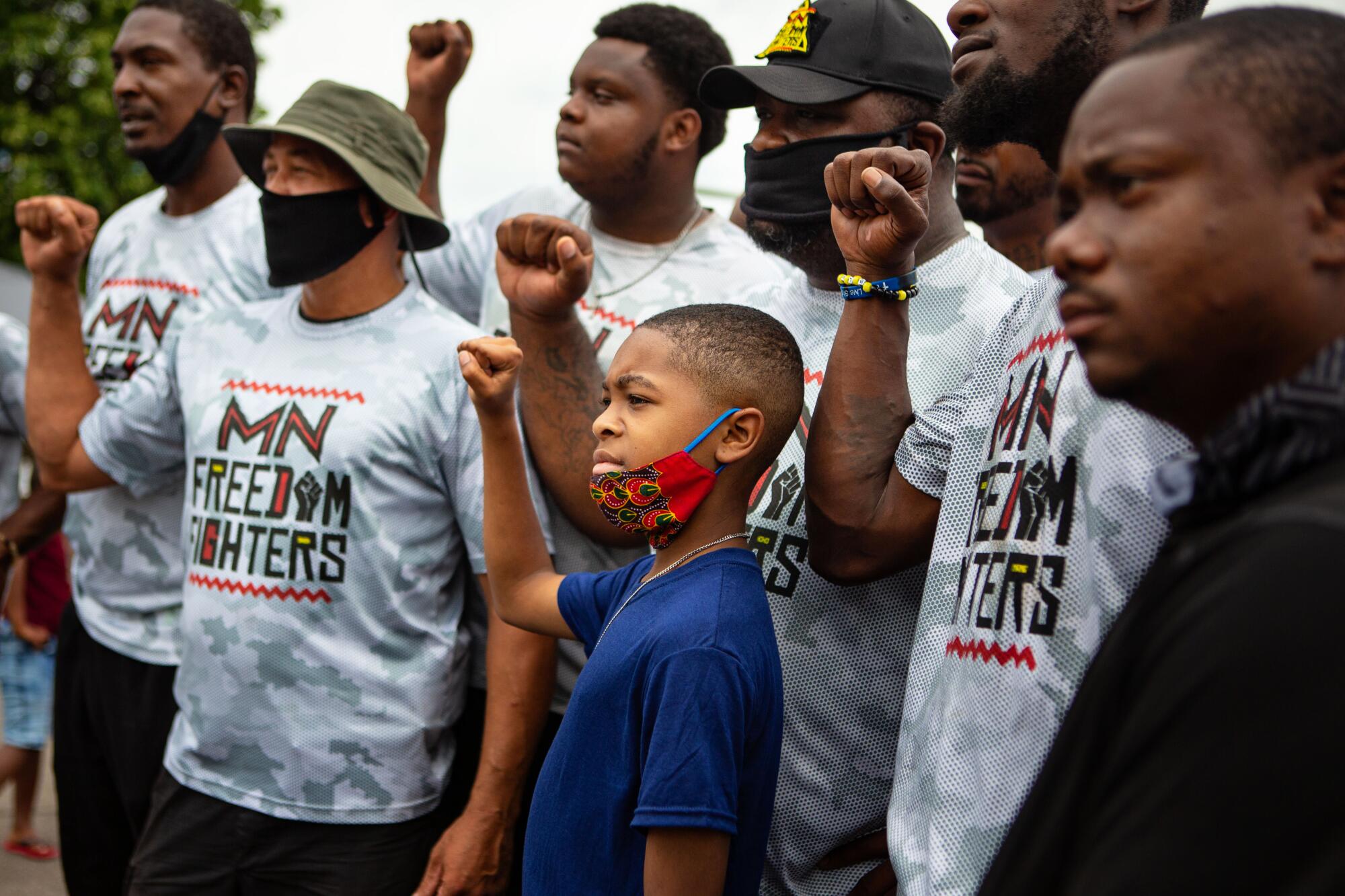 Members of the Minnesota Freedom Fighters pose for a photo with a boy at a community meet-and-greet.