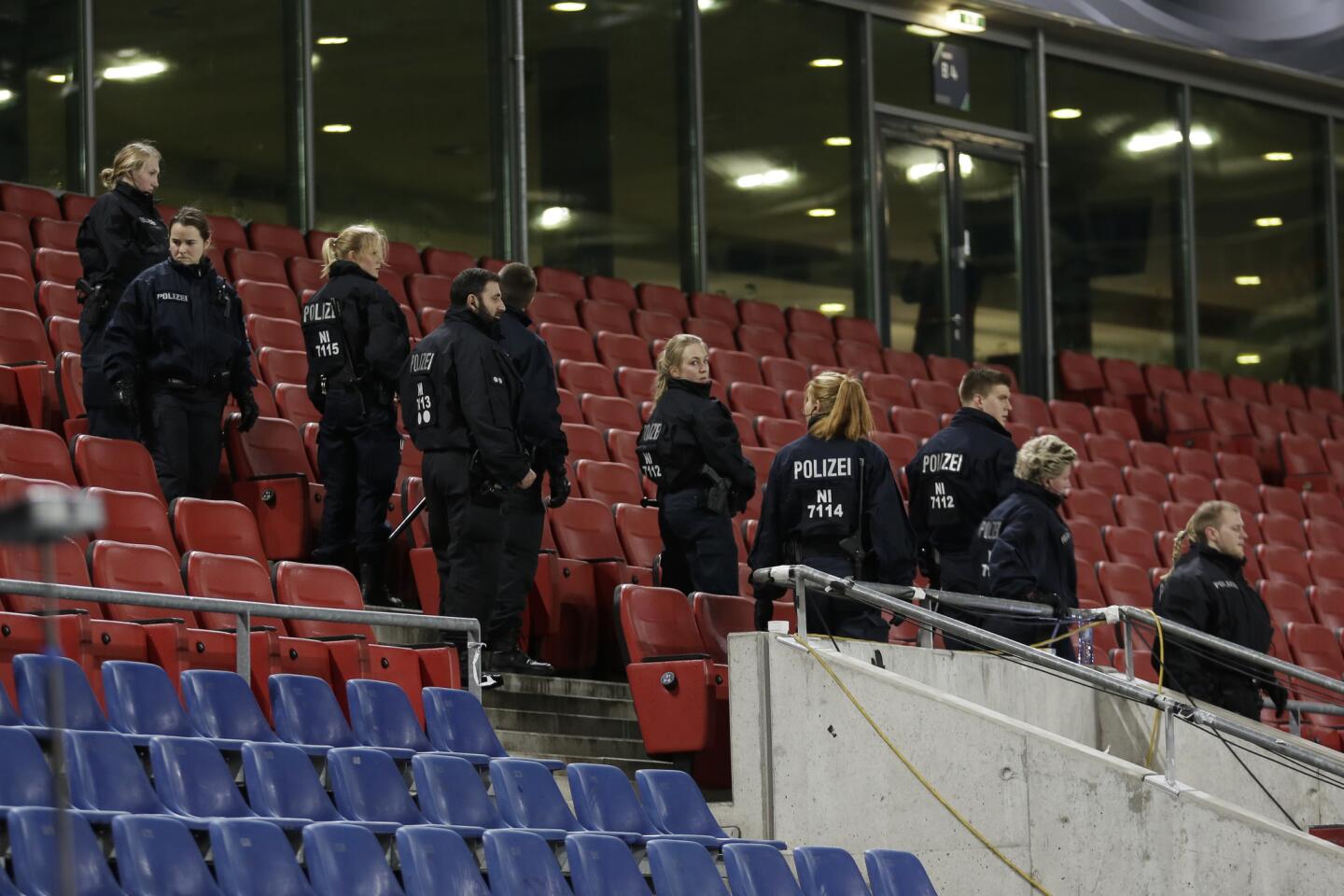 German police officers search between the seats of the stadium prior to an international friendly soccer match between Germany and the Netherlands in Hannover, Germany, Tuesday, Nov. 17, 2015. Following the Friday's attacks in Paris, security measures have been increased for the match.
