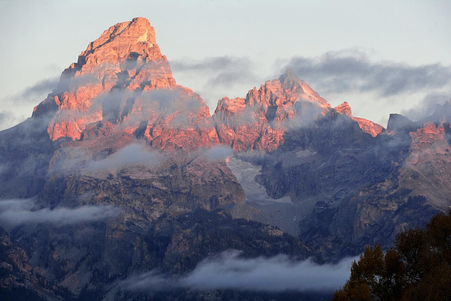 The morning sun hits the tips of the Grand Tetons.