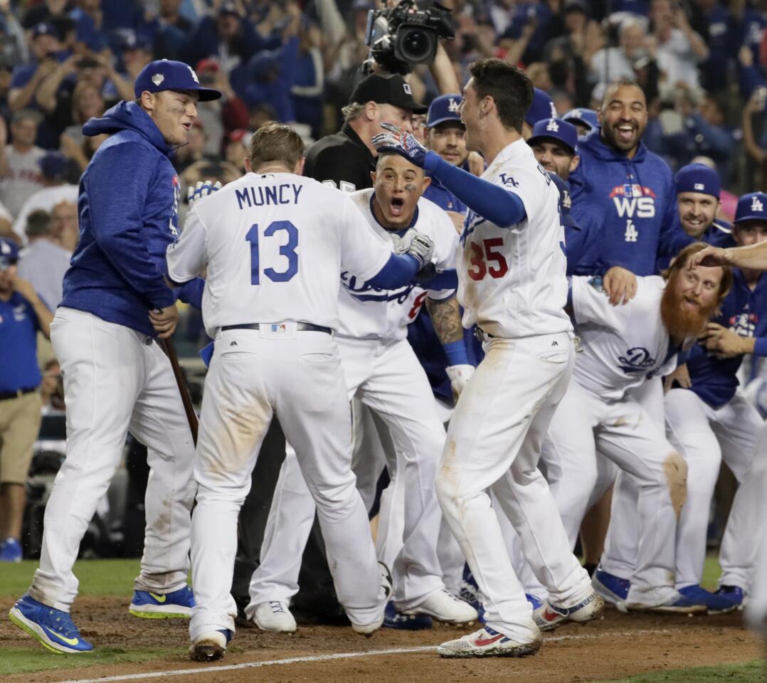 Dodger players celebrate as Max Muncy comes home after hitting the game-winning home run in the 18th inning against the Boston Red Sox.