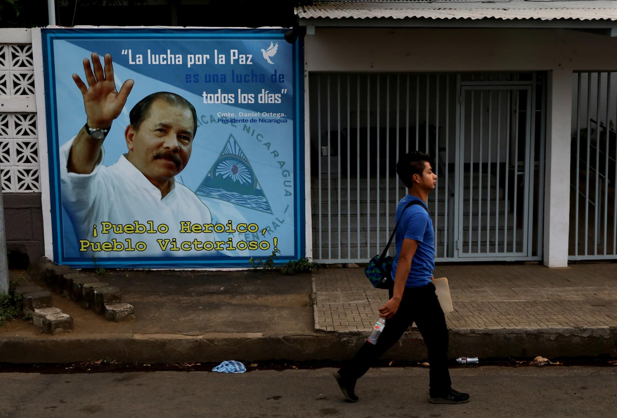 Man walks by a sign of the president.