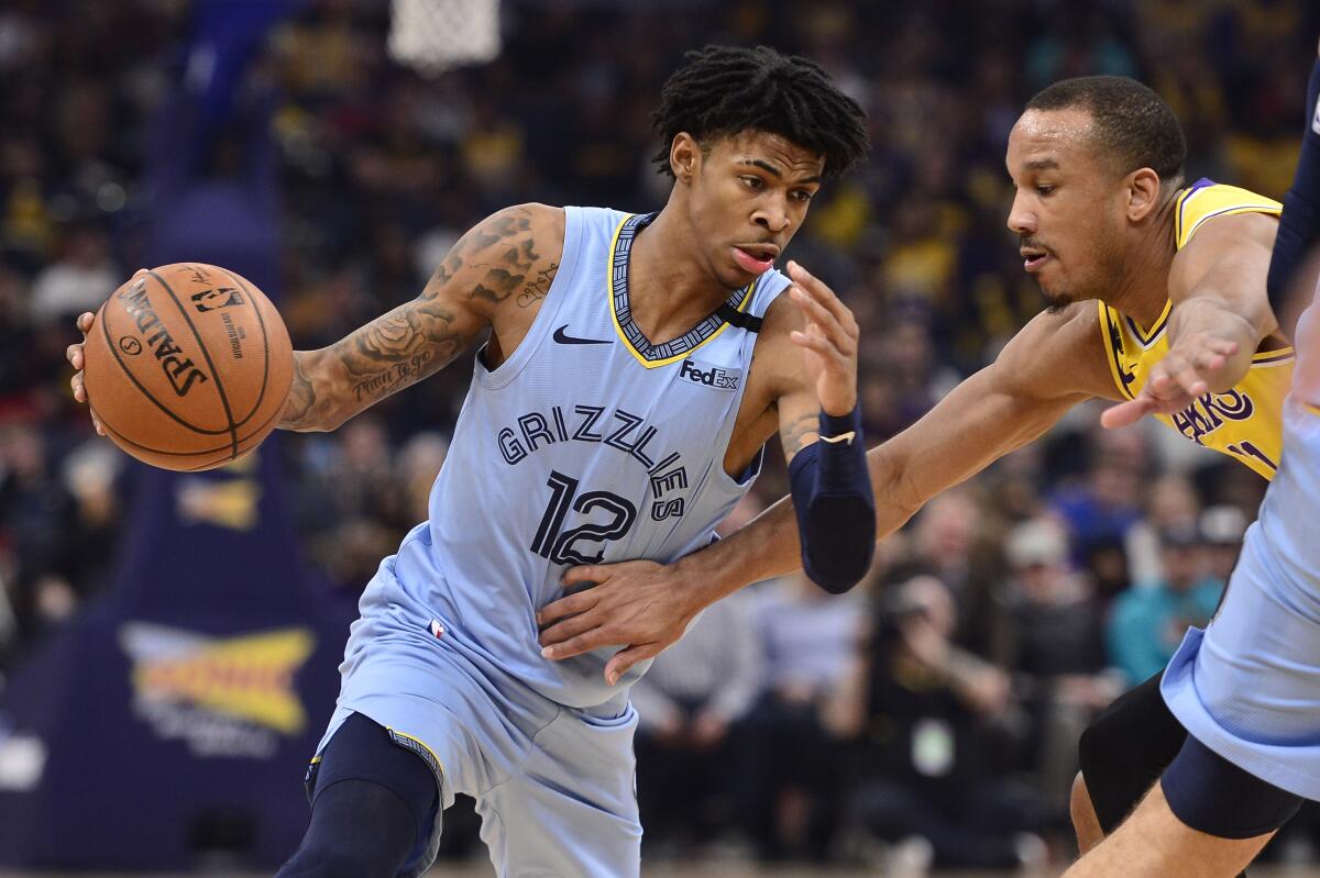 Grizzlies guard Ja Morant tries to shake Lakers guard Avery Bradley on a drive during the first half of a game Feb. 29, 2020, in Memphis, Tenn.