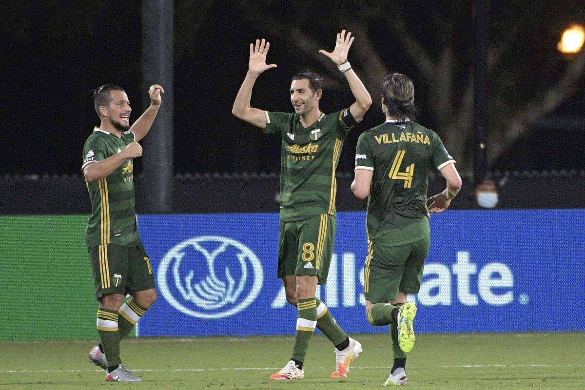 The Portland Timbers' Diego Valeri, middle, celebrates his goal with Sebastian Blanco, left, and Jorge Villafana.