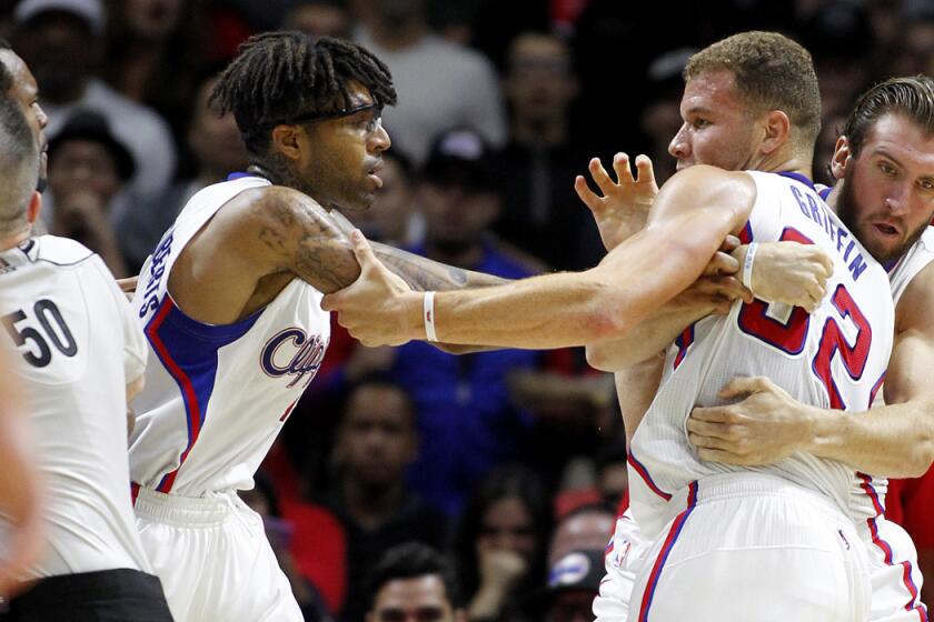 Clippers power forward Blake Griffin (32) is separated from Jazz forward Trevor Booker (left), who committed a hard foul, by referee Olandis Poole (50) as well as Clippers teammate Chris Douglas-Roberts (center) and Spencer Hawes in the second half.