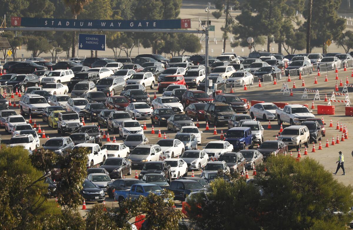 Several lanes of vehicles snake into Dodger Stadium parking lot between cones