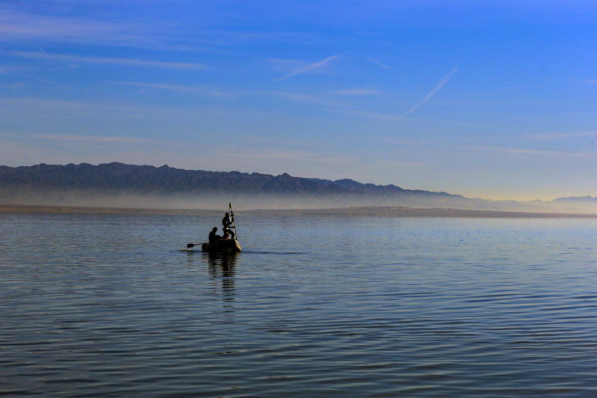 People are silhouetted on the Salton Sea.