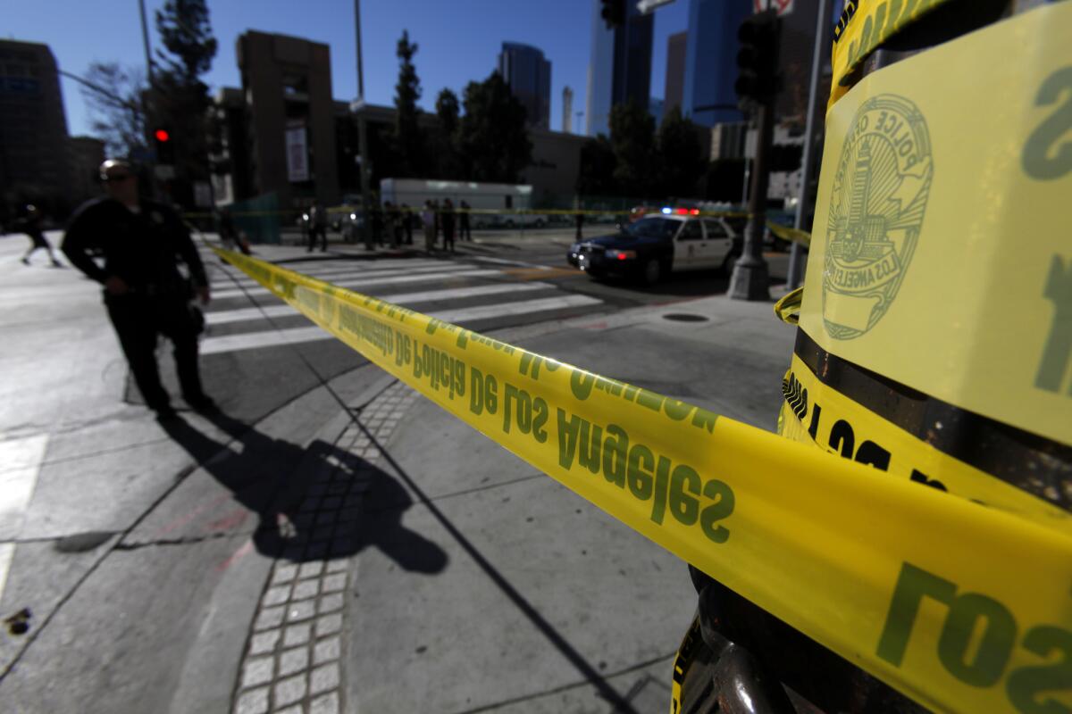 A Los Angeles police officer stands at the corner of 2nd and South Spring streets in downtown Los Angeles.