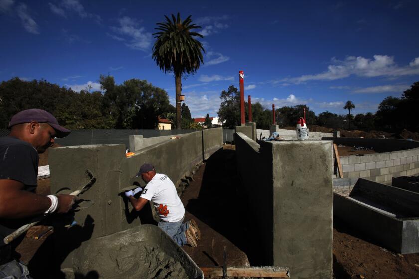 Constructions workers shown in November at an amphitheater being built at the West Los Angeles Veterans Affairs campus. A federal judge Thursday ordered the work halted.