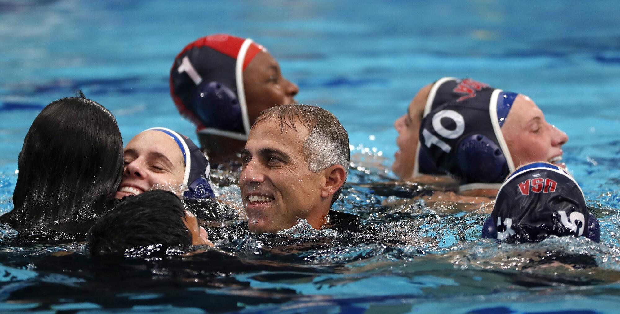 L'entraîneur de l'équipe américaine de water-polo féminin, Adam Krikorian, célèbre avec ses joueuses après la victoire de l'équipe pour la médaille d'or contre l'Espagne.