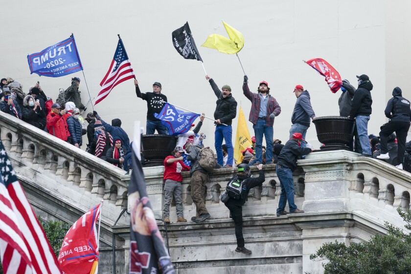 Archivo - Una turba agita banderas frente al Capitolio, en Washington, el 6 de enero de 2021.