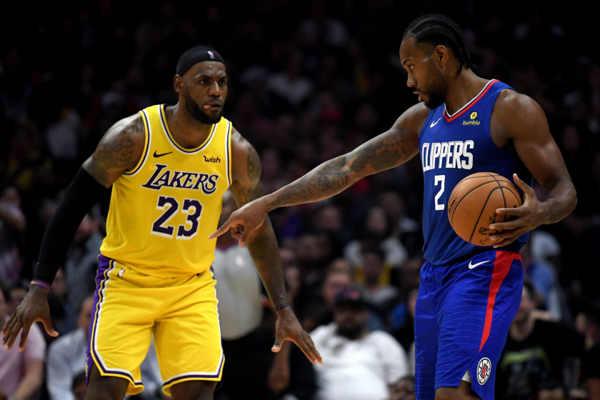 Kawhi Leonard of the Clippers controls the ball in front of Lakers forward LeBron James.