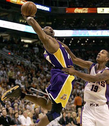 Lakers Kobe Bryant, left, is fouled by Raja Bell of the Phoenix Suns in the first quarter Thursday night.