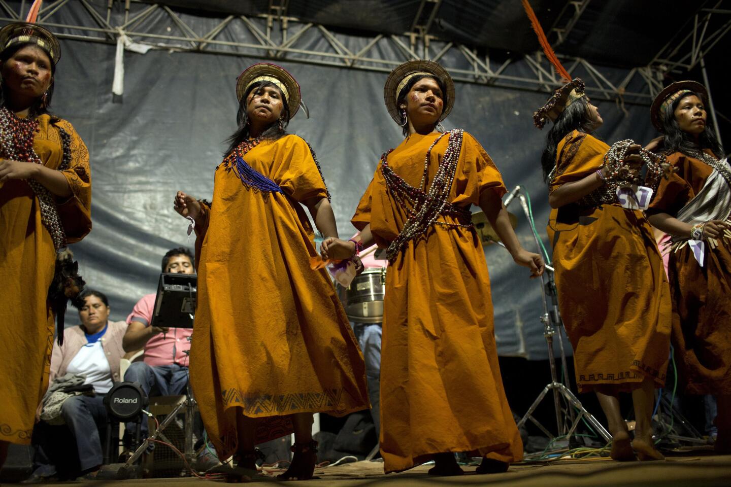 Concursantes de un certámen de belleza asháninka bailan sobre el escenario, en uno de los actos con loa que se celebra la fundación de la comunidad de Otari Nativo.