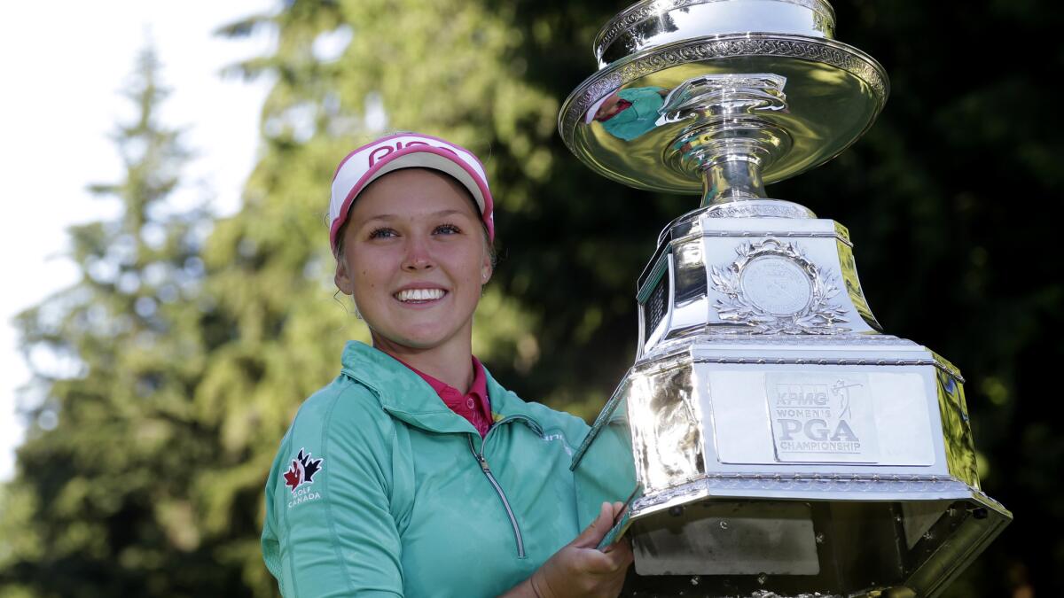 Brooke Henderson lifts the championship trophy after winning the Women¿s PGA Championship golf tournament at Sahalee Country Club on Sunday.