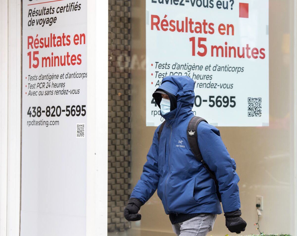 A man walks by a COVID-19 rapid testing business in Montreal, Saturday, Dec. 4, 2021. (Graham Hughes/The Canadian Press via AP)