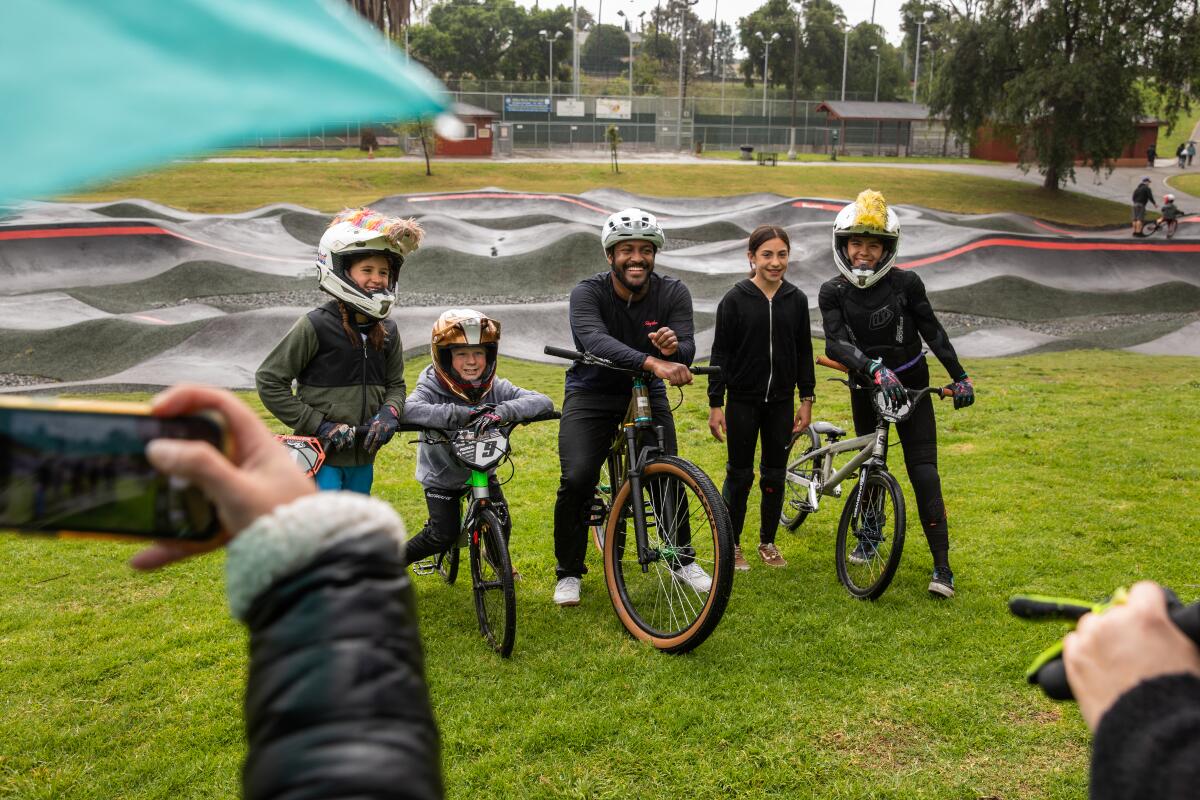 Eliot Jackson, a pro mountain biker, center, poses with young BMX athletes at the Inglewood Pumptrack. 