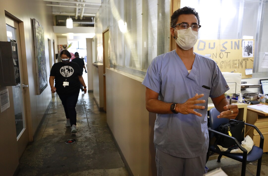 Dr. Rolando Tringale works with clients at the front door of the Center for Harm Reduction in skid row