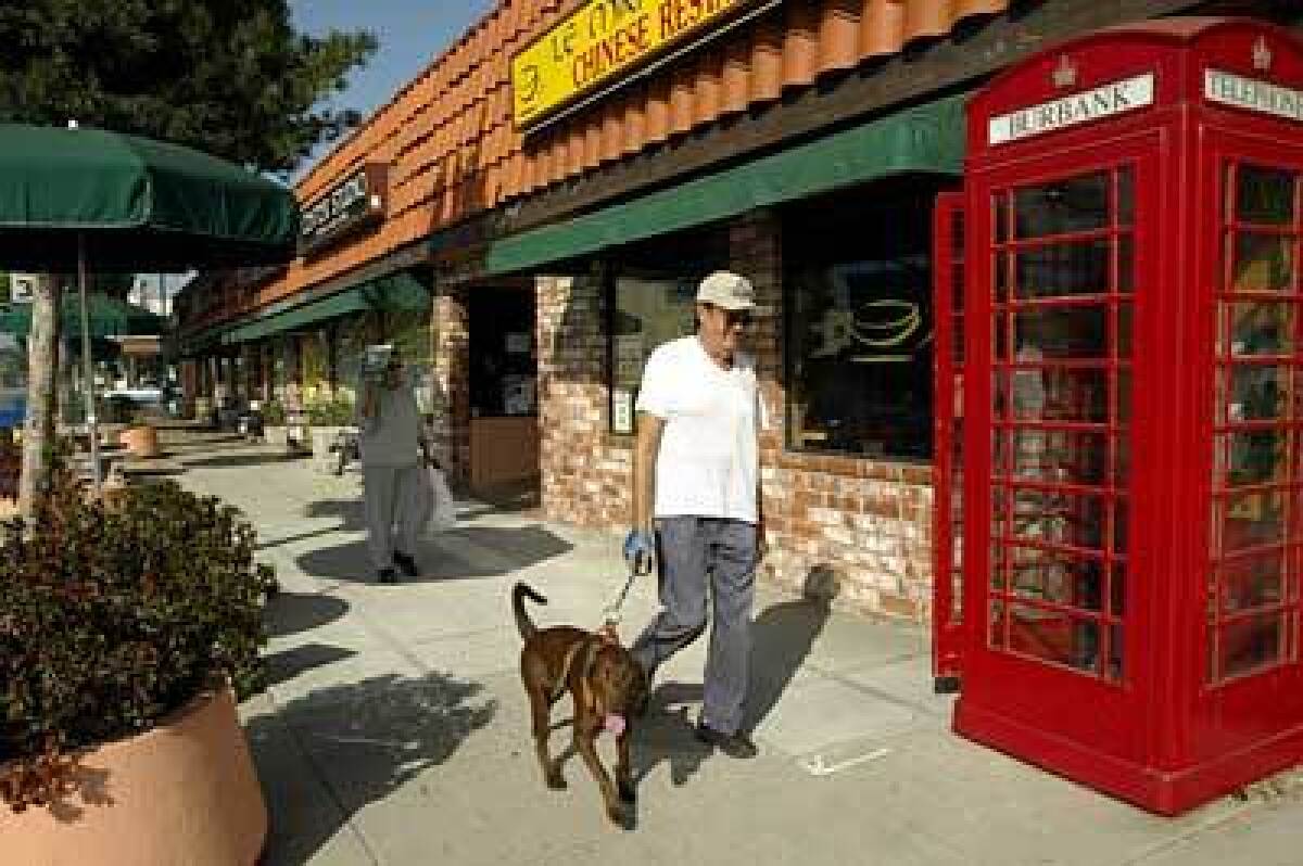 James Barajas and his dog walk through the business district along Magnolia Boulevard.