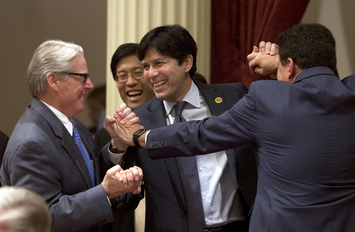State Senate leader Kevin de León, center, celebrates with fellow lawmakers after the Senate in August approved his bill creating a retirement savings program for private workers.