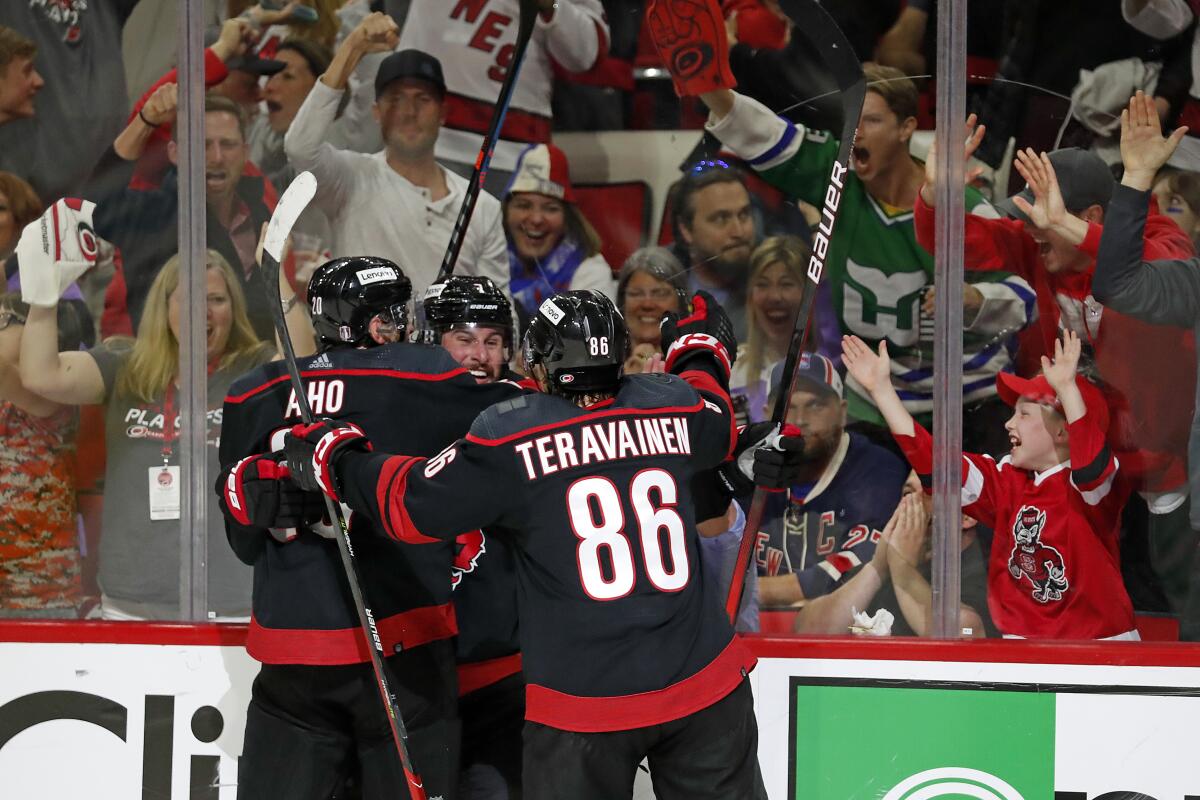 Carolina Hurricanes' Brendan Smith, center, celebrates his goal with teammates Sebastian Aho (20) and Teuvo Teravainen (86) during the second period of Game 2 of an NHL hockey Stanley Cup second-round playoff series in Raleigh, N.C., Friday, May 20, 2022. (AP Photo/Karl B DeBlaker)