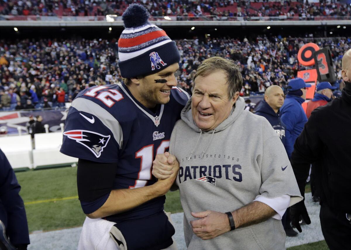 Patriots quarterback Tom Brady, left, celebrates with coach Bill Belichick after defeating the Miami Dolphins in 2014.