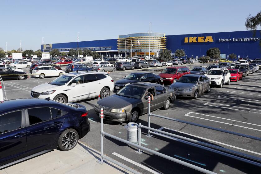 Hundreds of vehicles line up for a drive-thru giveaway at IKEA to receive emergency food boxes filled with essential staples such as rice, beans, pasta and fresh produce to 1,200 low-income families in Costa Mesa on Thursday, April 23, 2020.