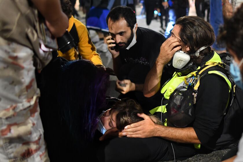 Paramedics treat a protester who was run over by a car on Sunset Boulevard on Thursday night.