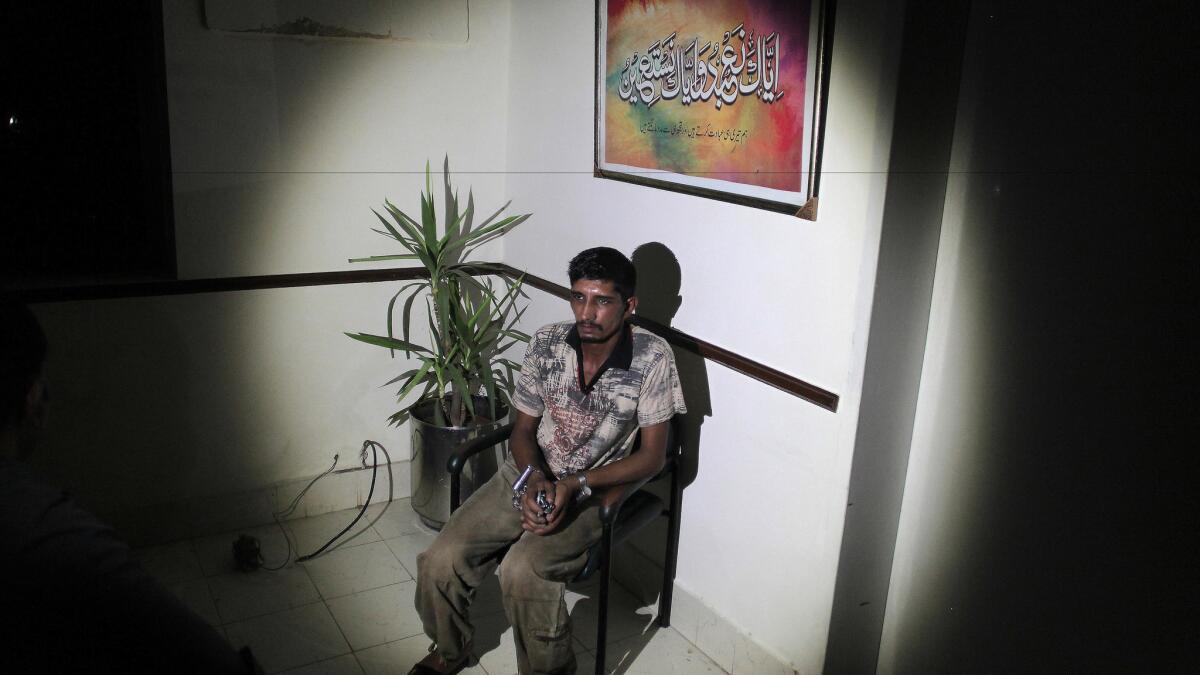 Mubeen Rajhu, who killed his sister Tasneem, sits at police headquarters in Lahore, Pakistan, on Sept. 1.