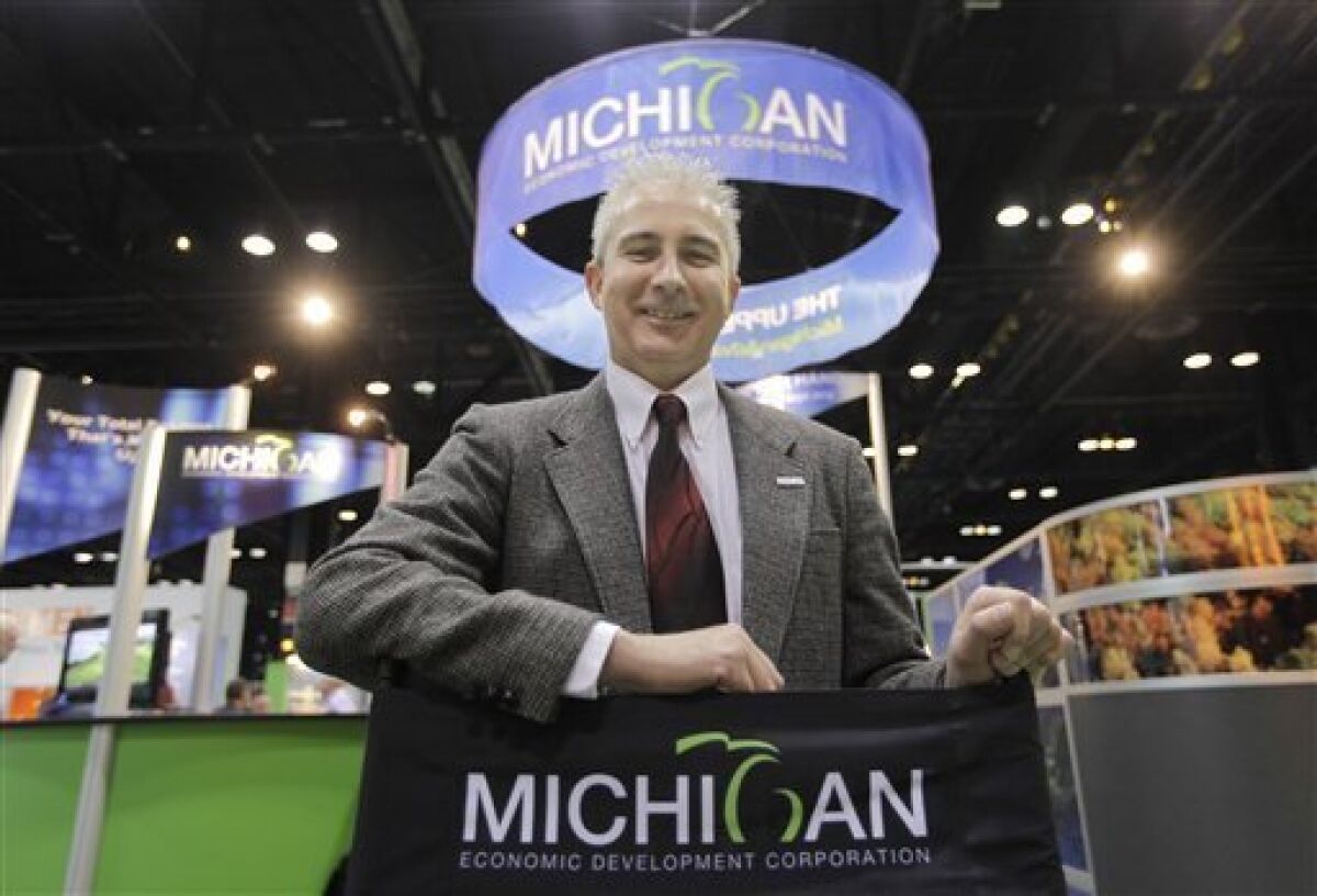 Pete Ostrander, a sales engineer with Merrill Technologies Group from Saginaw, Michigan, mans the Michigan booth at the Windpower 2009 Conference & Exhibition Thursday, May 7, 2009, in Chicago. Merrill is like dozens of companies at the convention who have traded their auto-related business for a niche in the wind-power business or moved into wind power as they hedge their bets on increasingly troubled American automakers. (AP Photo/M. Spencer Green)