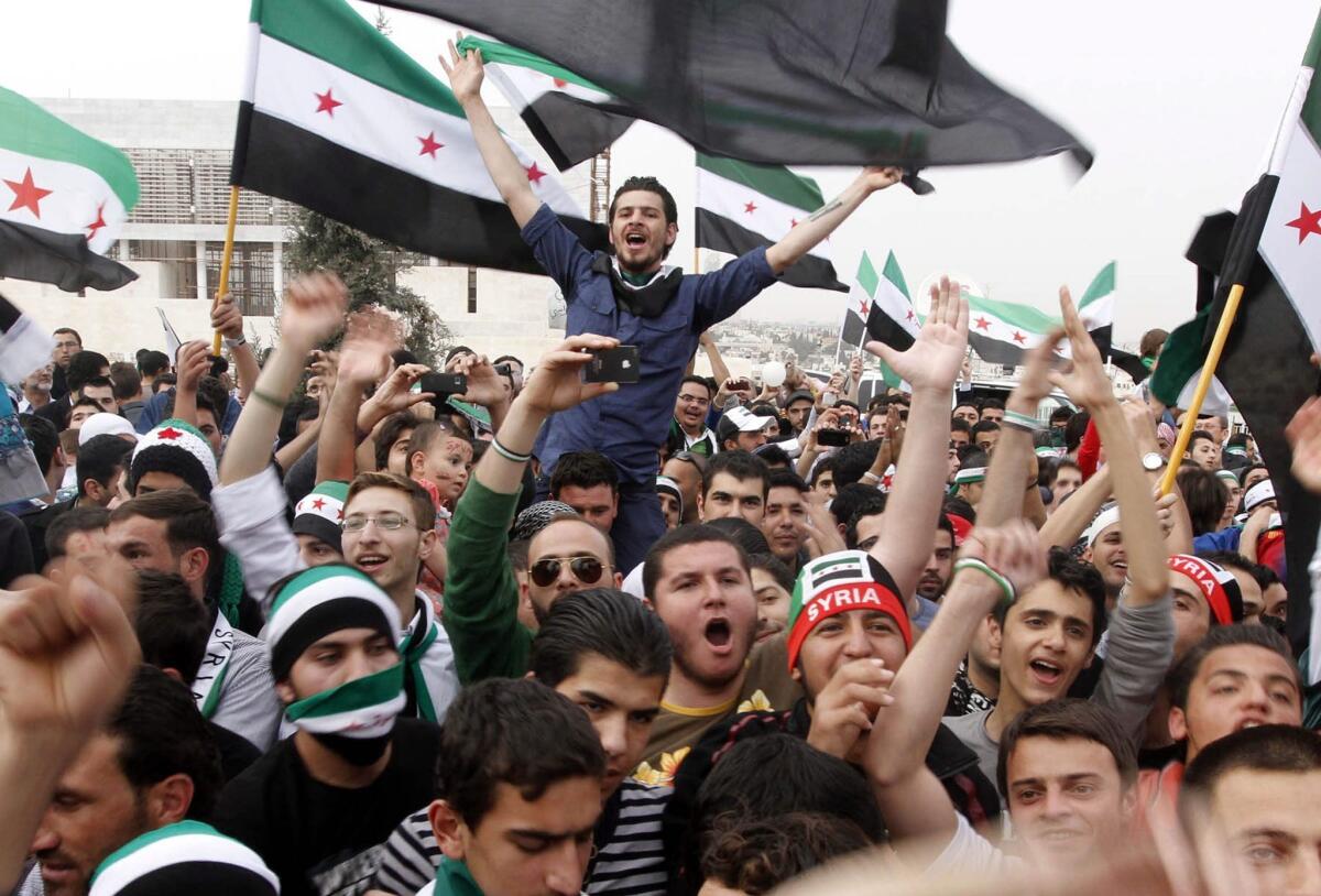Hundreds of people gather in front of the Syrian embassy in Amman, Jordan, to mark the second anniversary of the fighting between Syrian opposition forces and forces loyal to President Bashar Assad.