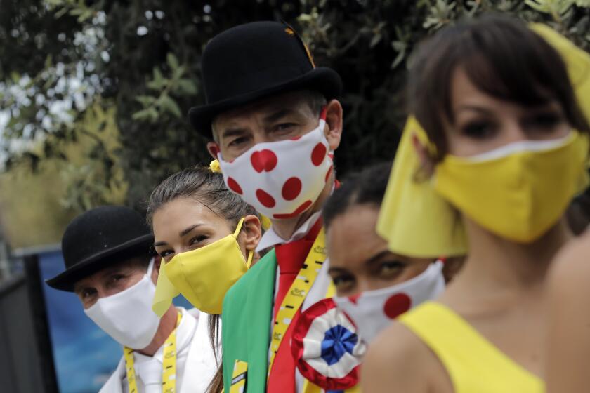 Tour de France hostess wear face masks prior to the start of the first stage of the Tour de France cycling race over 156 kilometers (97 miles) with start and finish in Nice, southern France, Saturday, Aug. 29, 2020. (AP Photo/Christophe Ena)