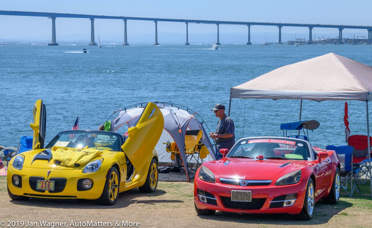 The car show with the Coronado Bay Bridge in the background