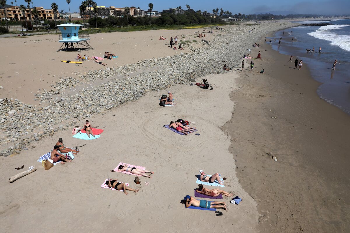 Visitors practice social distancing at the beach in Ventura on Saturday.