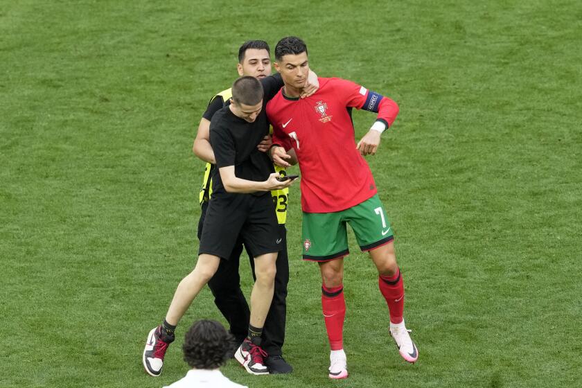 Un aficionado toma del cuello a Cristiano Ronaldo durante el duelo de Portugal del Grupo F ante Turquía en la Eurocopa el sábado 22 de junio del 2024. (AP Foto/Michael Probst)