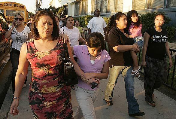 Anxious parents arrive at George Washington Carver Middle School in South L.A. after a gunman opened fire at a busy intersection nearby. The bloodshed extended a string of unconnected mass shootings in recent weeks across Los Angeles and Orange counties.