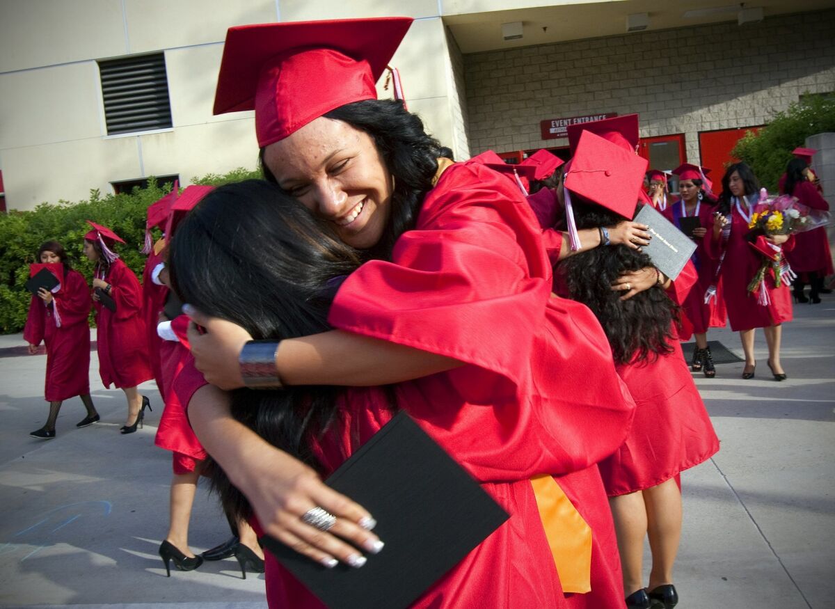 At Hoover High School's graduation held on campus at SDSU, Viejas Arena, graduates Mayreni Olea and Daisy Mercado embrace one another after their high school graduation.