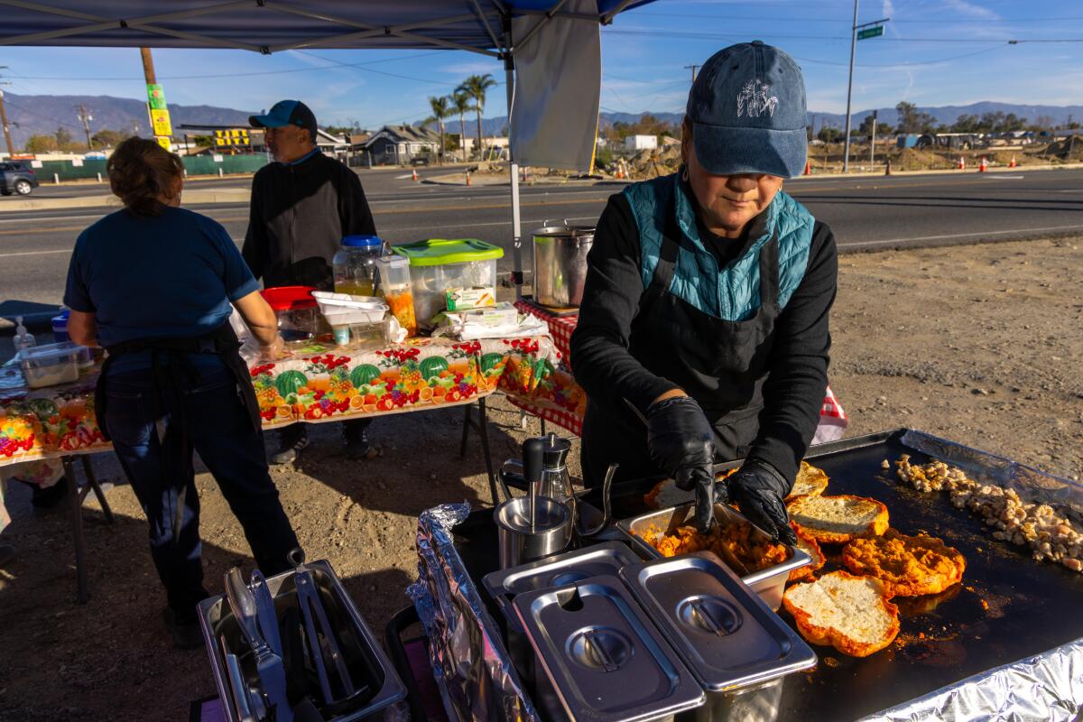 A woman cooks pambazo at her food stand.