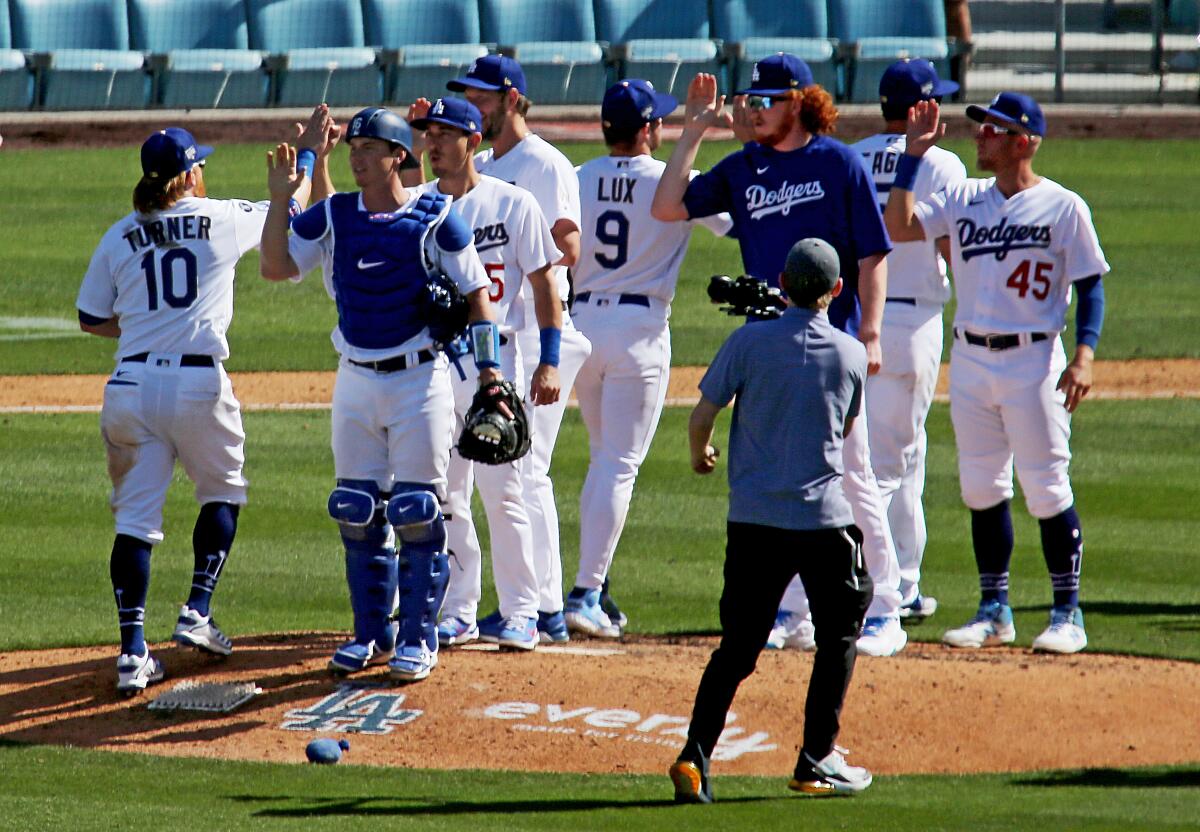 The Dodgers celebrate a 1-0 victory over the Nationals in the home opener.
